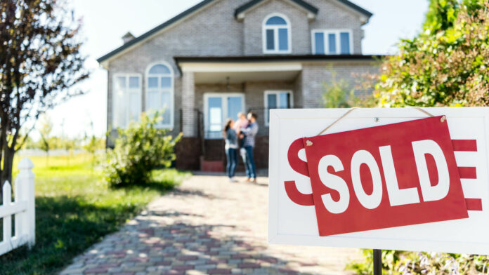 Sold,House,With,Blurred,Family,On,Background