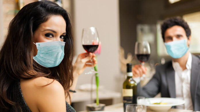 Couple,Toasting,Wineglasses,In,A,Luxury,Restaurant,And,Wearing,Masks,
